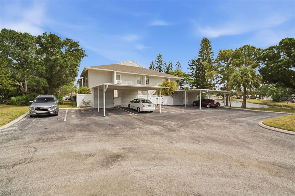 A two-story building with a covered parking area and three cars parked in front — 8350 SAVANNAH TRACE CIRCLE UNIT 305, TAMPA, FL