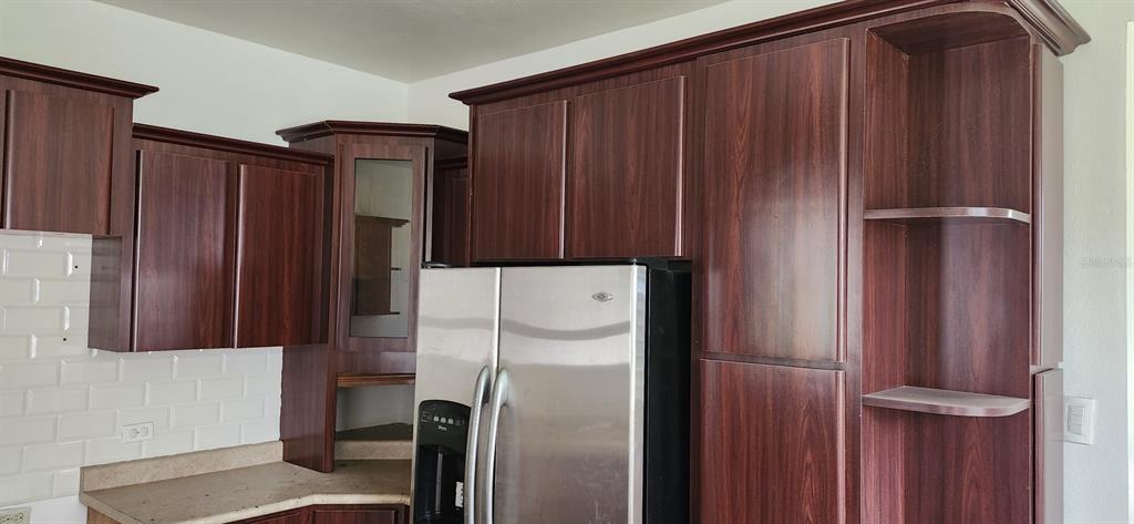 A kitchen features dark wood-grain cabinets, a stainless steel refrigerator, and white subway tile backsplash — 480 CALLE S. TOSADO, QUEBRADILLAS, PR