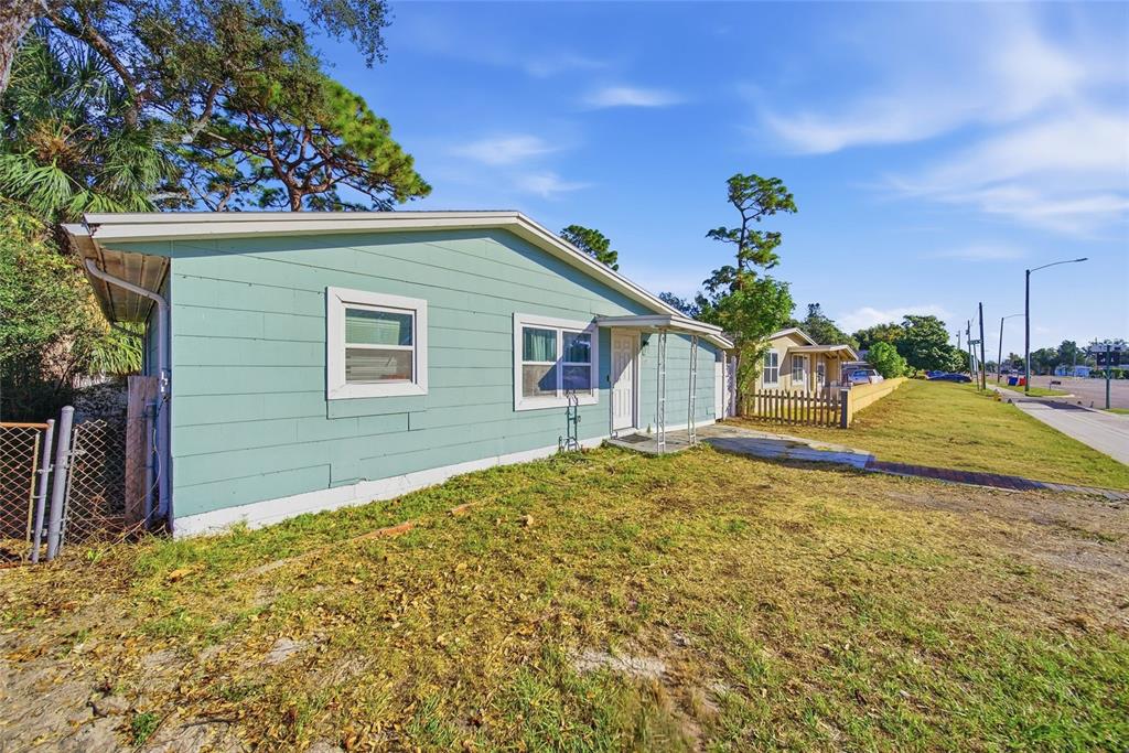A light blue, single-story house with a white door and windows sits on a grassy lot — 7095 54TH AVENUE N, ST PETERSBURG, FL
