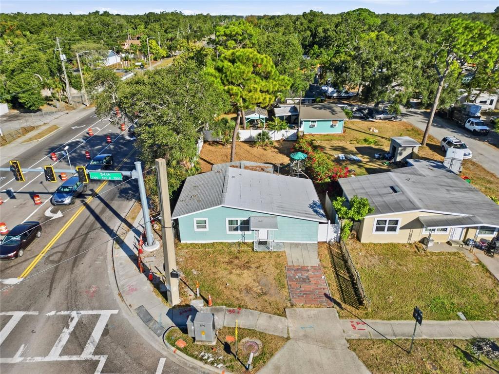 An aerial view shows two adjacent single-story houses near a street intersection with traffic lights — 7095 54TH AVENUE N, ST PETERSBURG, FL