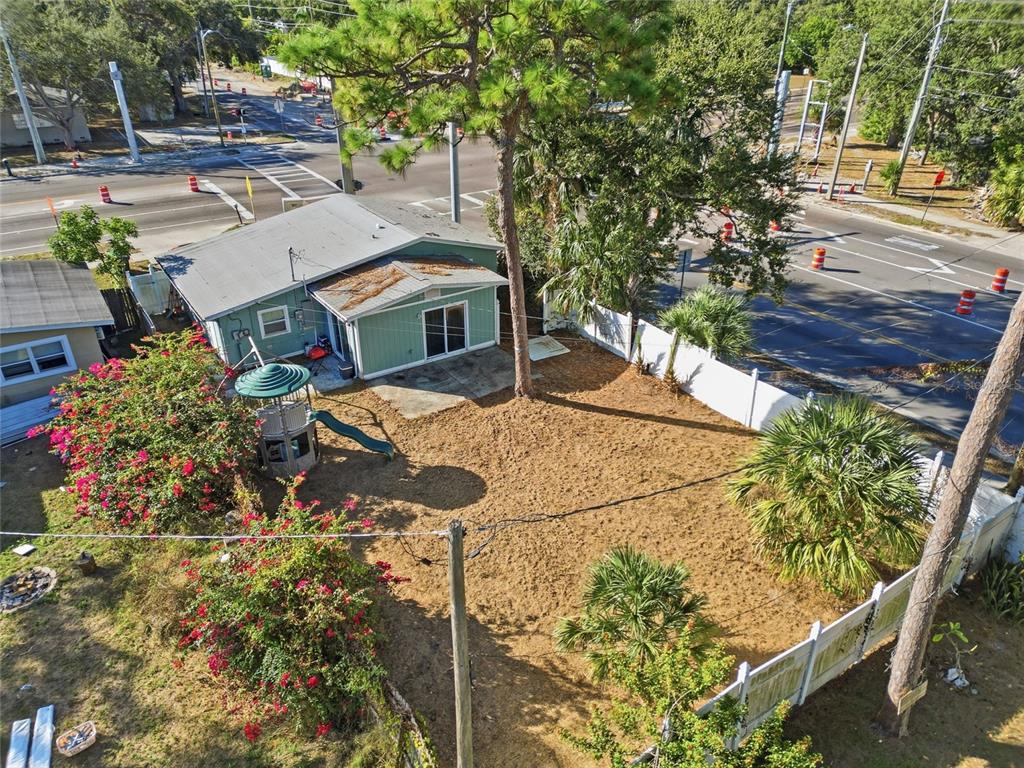 An aerial view shows a house with a fenced backyard, a playground, and nearby roads — 7095 54TH AVENUE N, ST PETERSBURG, FL