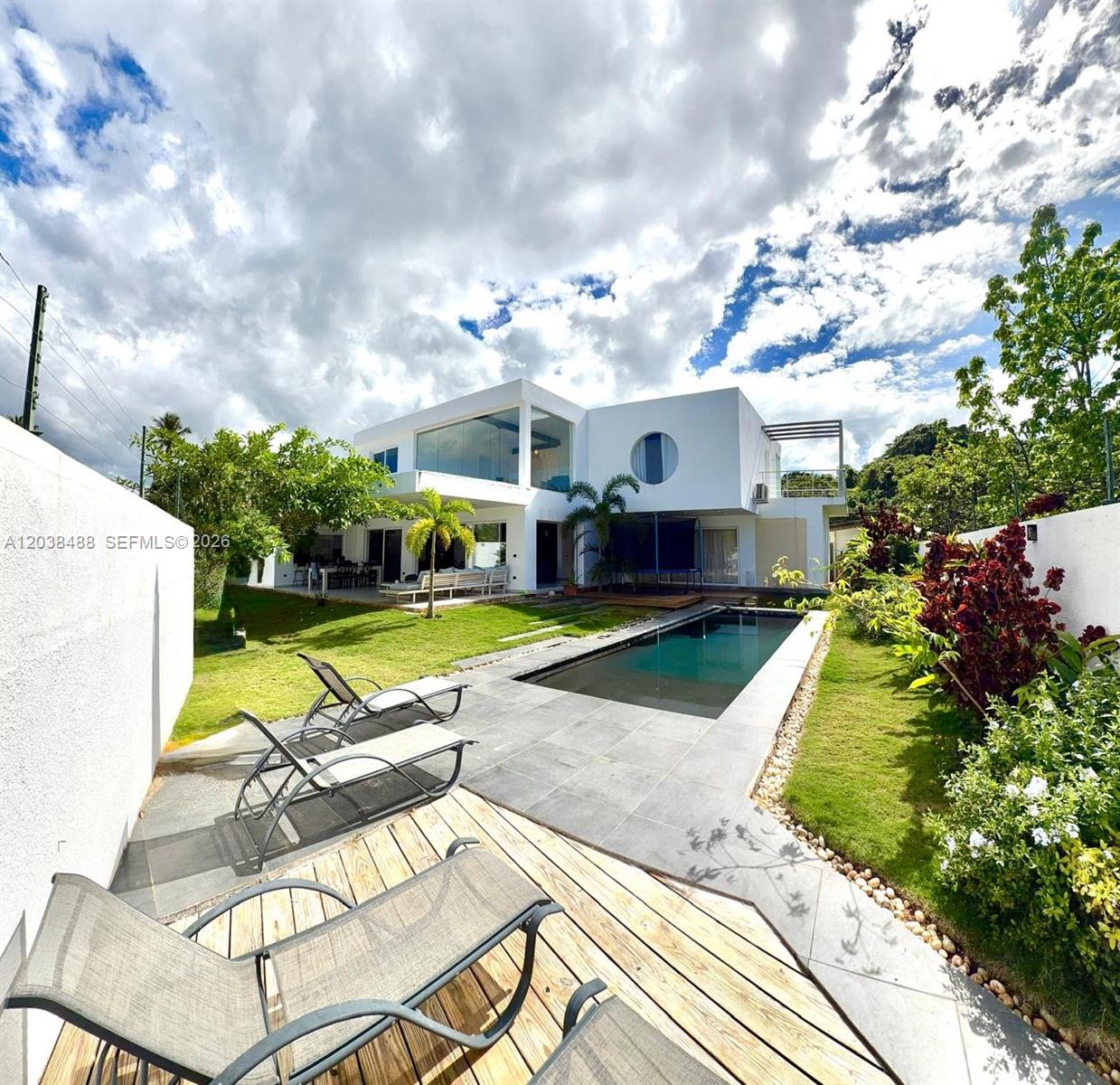 A modern white two-story house features a backyard with a swimming pool and lounge chairs — 00 CALLE MARIANO VANDERHORST, 3200, FL