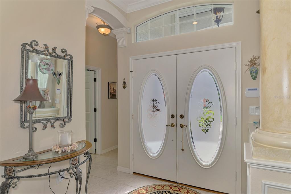 An entryway features double doors with oval glass inserts, a console table, and a mirror — 625 MISTY PINE DRIVE, VENICE, FL