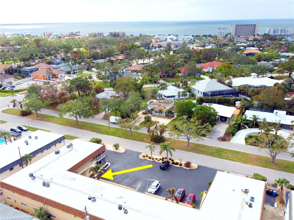 An aerial view shows a commercial building with a parking lot and surrounding residential neighborhood — 210 PARK BOULEVARD N UNIT 129, VENICE, FL