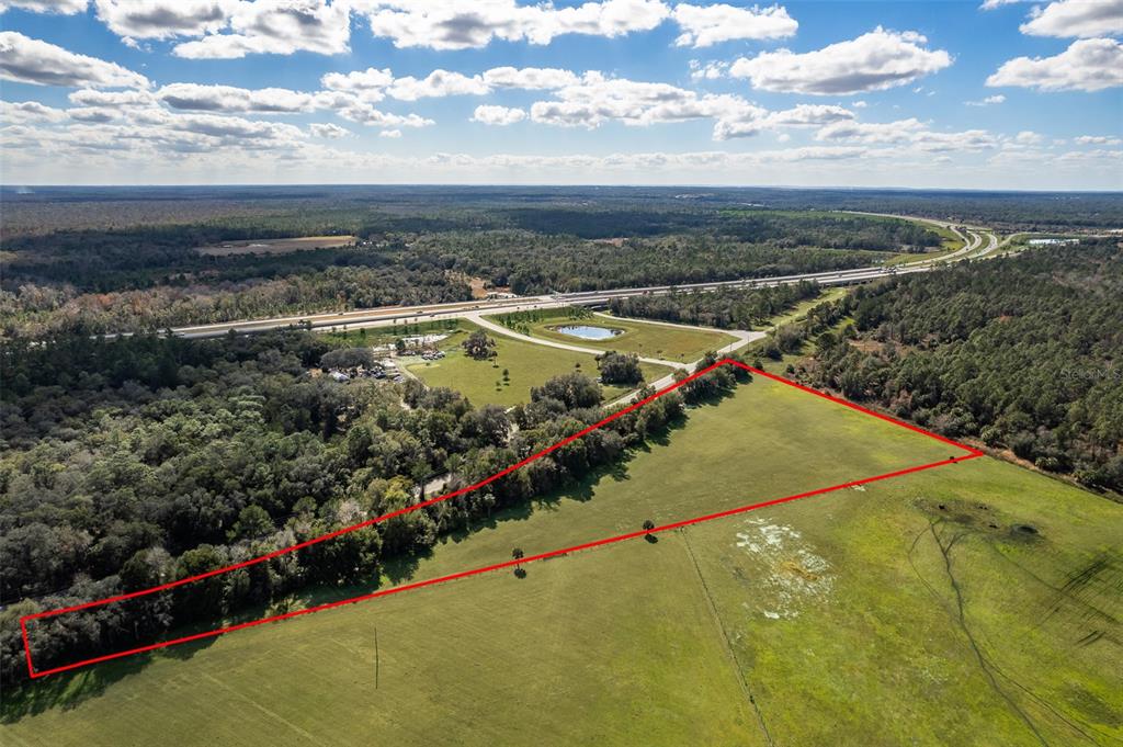 An aerial view shows a large, grassy, triangular plot of land outlined in red — CYPRESS MILL ROAD, SORRENTO, FL