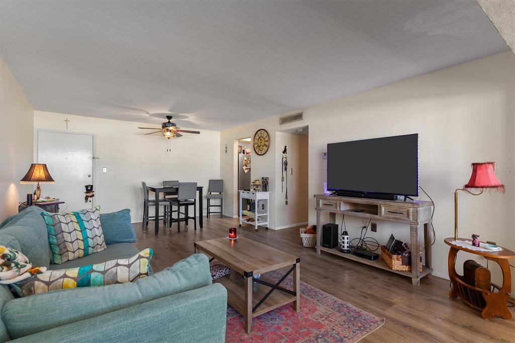 A living room features a blue sofa, a wooden coffee table, and a television console — 2437 HARBOR BOULEVARD UNIT 204, PORT CHARLOTTE, FL