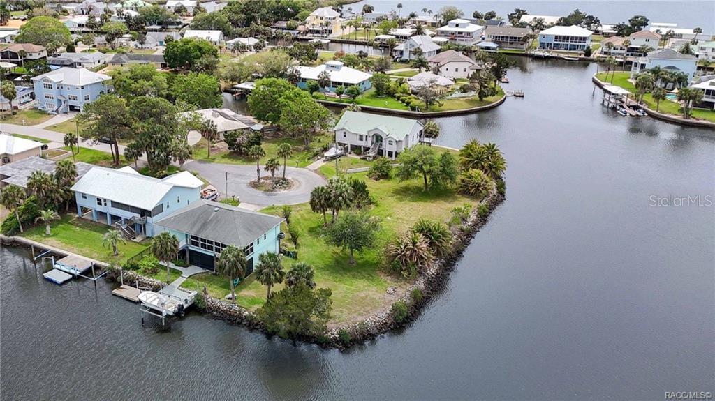 An aerial view shows waterfront houses with private docks along a canal in a neighborhood — 11889 W COQUINA COURT, CRYSTAL RIVER, FL