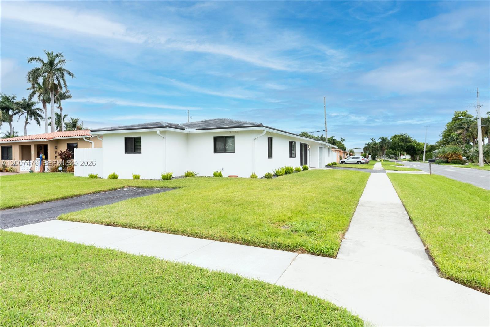A white single-story house with a dark roof sits on a corner lot with grass — 510 SE 3rd Ave # A, Dania Beach FL 33004, DANIA BEACH, FL
