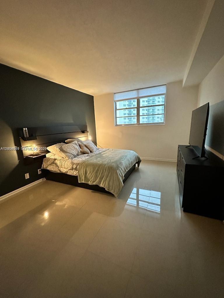 A bedroom features a dark accent wall, a platform bed, and a large television console — 3000 S Ocean Dr # 414, Hollywood FL 33019, HOLLYWOOD, FL