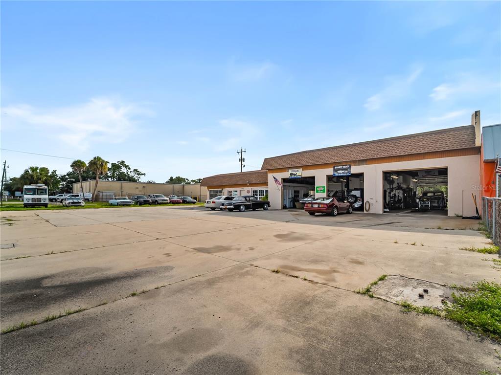 An exterior view of an auto repair shop with a large concrete parking lot — 101 S INDIANA AVENUE, ENGLEWOOD, FL