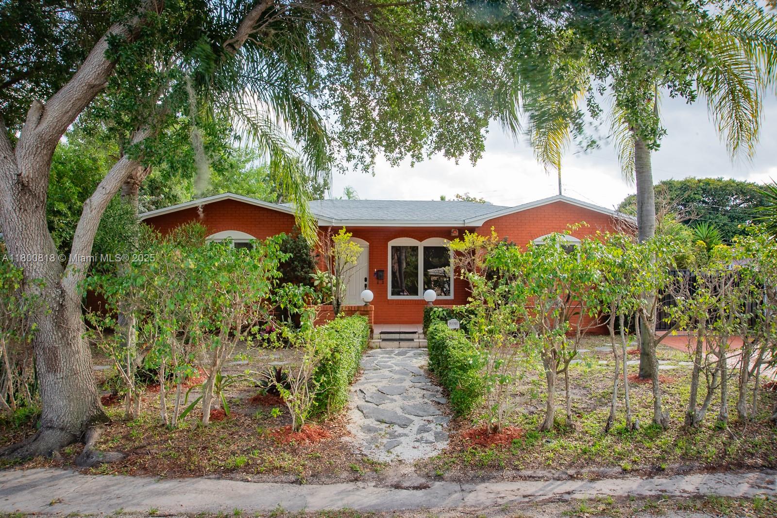 A single-story red brick house features a stone walkway leading to the front entrance — 16910 NE 8th Ct, North Miami Beach FL 33162, NORTH MIAMI BEACH, FL