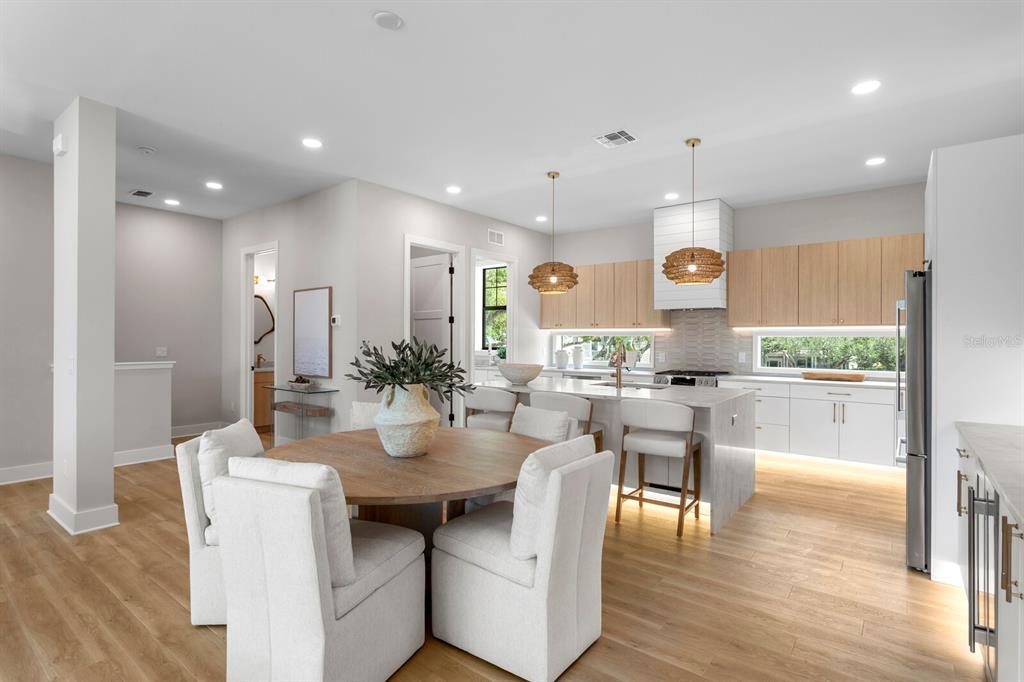 A modern kitchen and dining area features light wood floors, white cabinets, and a central island — 5210 BAYSHORE BOULEVARD UNIT 3, TAMPA, FL