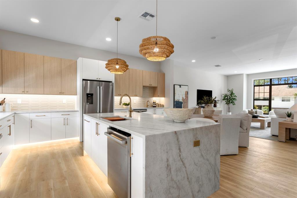 A modern kitchen features light wood cabinets, a marble island, and pendant lighting — 5210 BAYSHORE BOULEVARD UNIT 3, TAMPA, FL