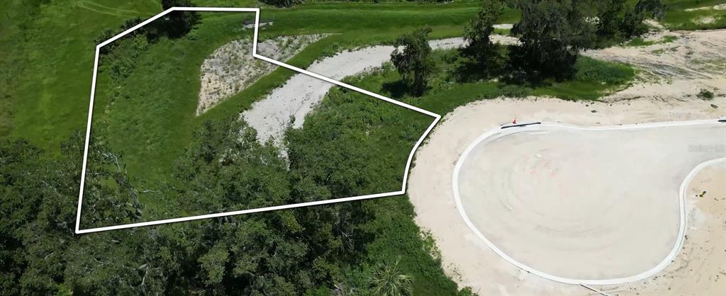 An aerial view shows a vacant, irregularly shaped residential lot adjacent to a paved cul-de-sac — 133 TRANQUIL MIRROR LAKE COURT Lot 16, CLERMONT, FL