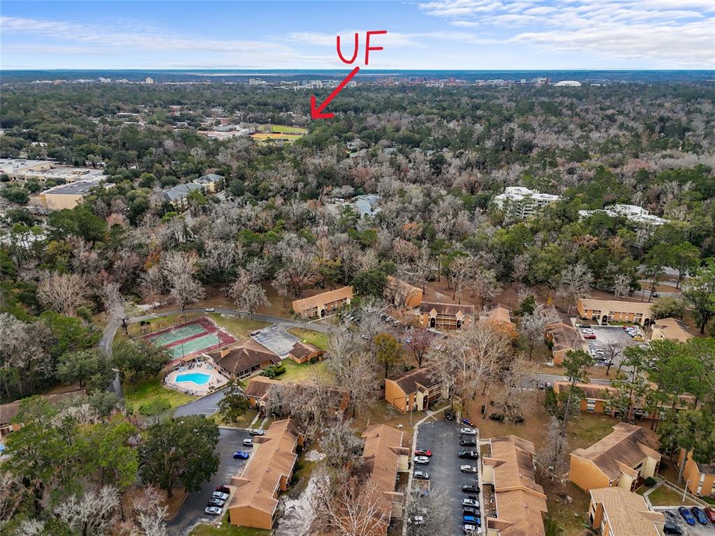 An aerial view shows a multi-family residential complex with a pool and tennis court — 1810 NW 23RD BOULEVARD UNIT 202, GAINESVILLE, FL