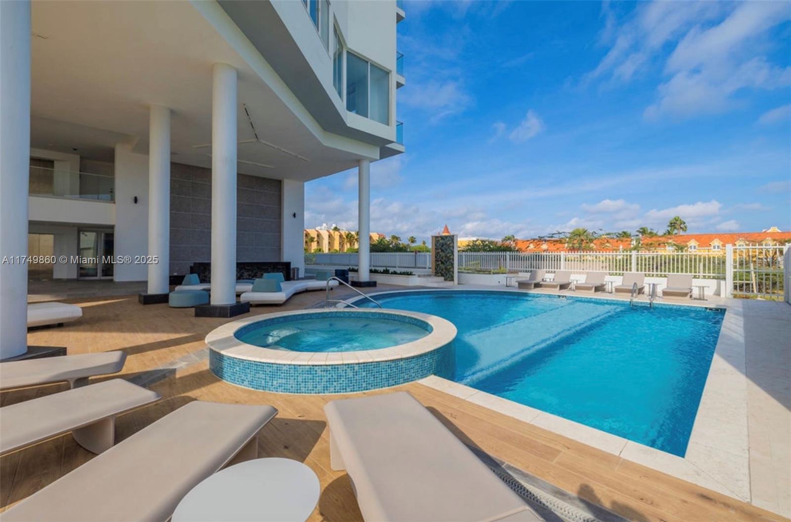 A swimming pool and hot tub are located on a patio with lounge chairs — 1 NW IRAUSQUIN BLV # 1A, Au, Au