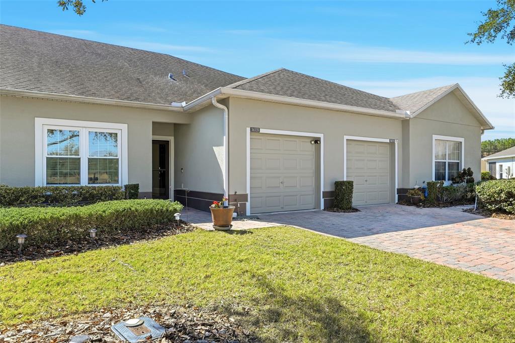A single-story house exterior features a two-car garage, a paved driveway, and a front lawn — 3632 SOLANA CIRCLE UNIT B, CLERMONT, FL