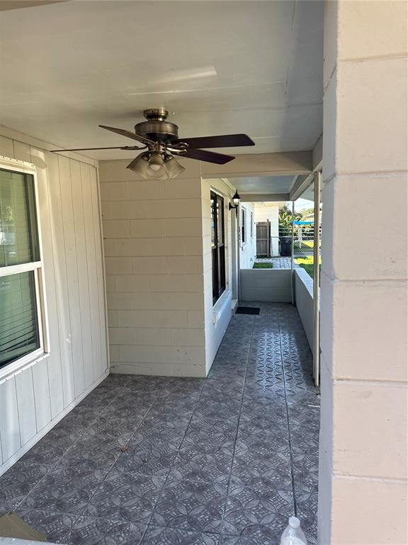 A covered outdoor patio features a ceiling fan, tiled flooring, and concrete block walls — 821 THALIA DRIVE, ORLANDO, FL