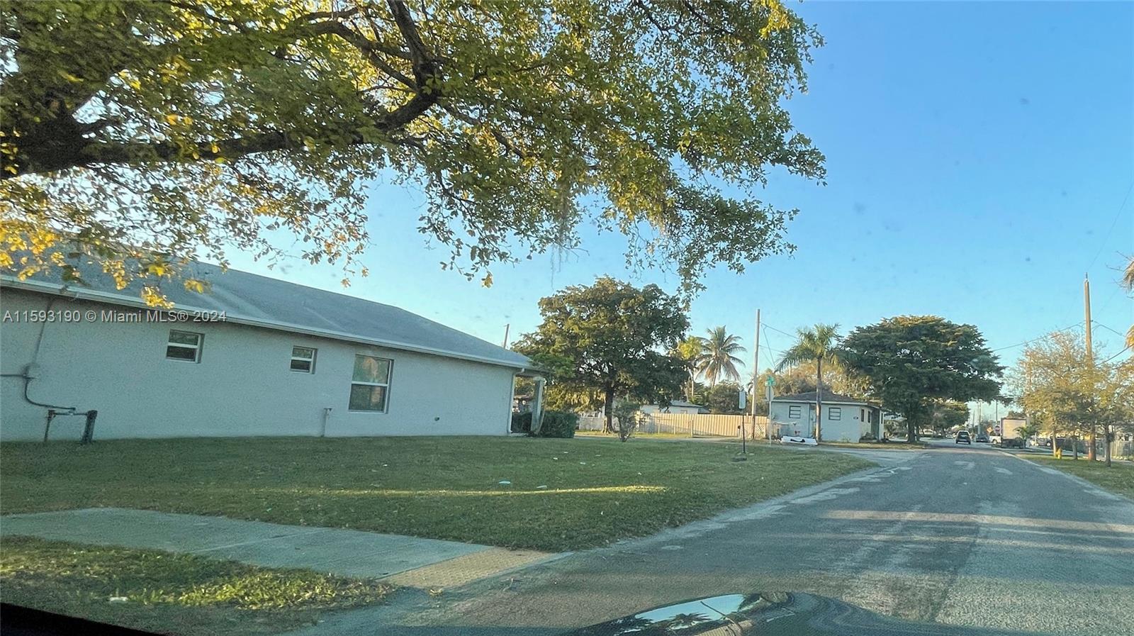 A single-story house with a light-colored exterior sits on a corner lot with trees — 6 Nw Ave, Hallandale Beach FL 33009, HALLANDALE BEACH, FL