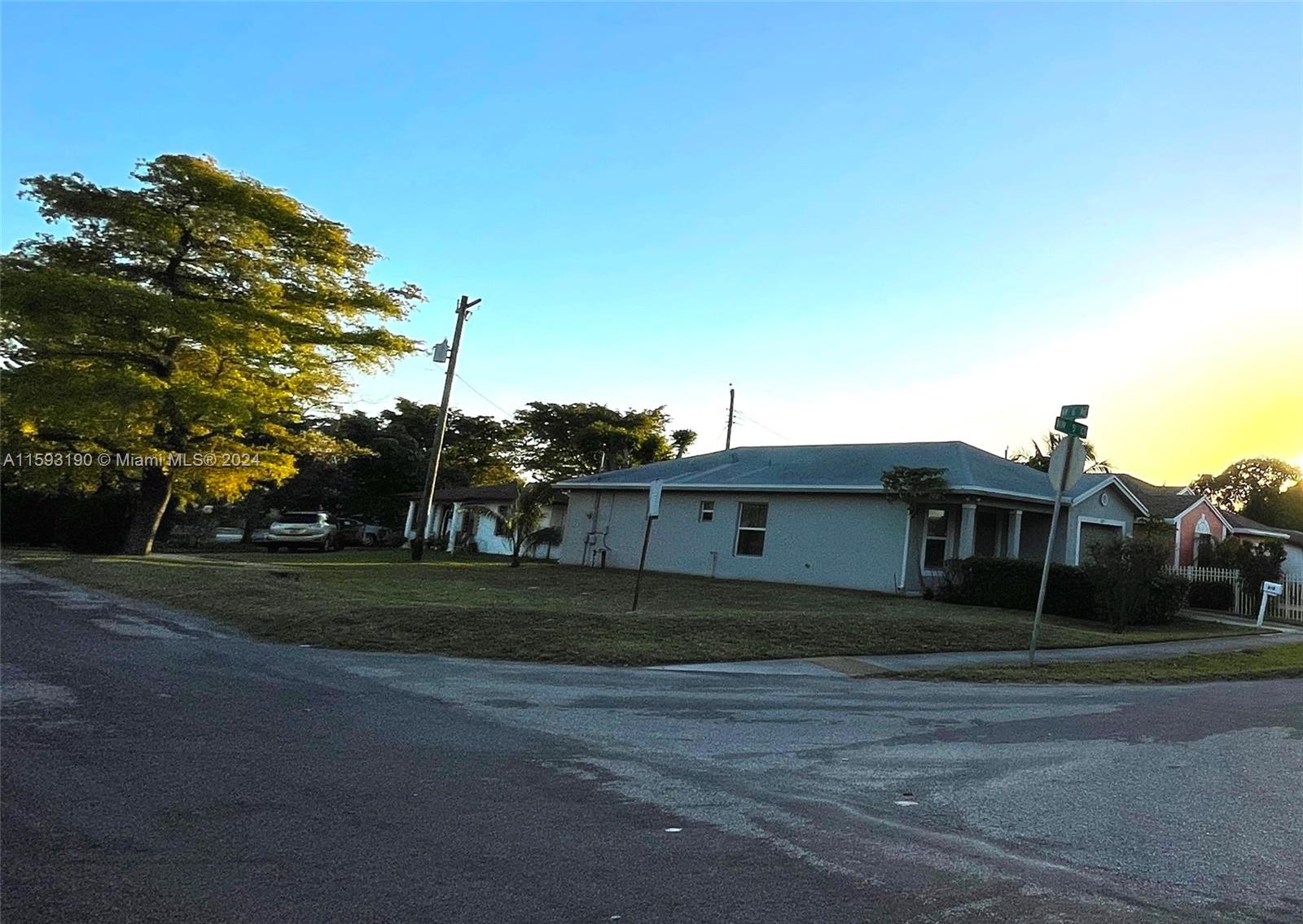 A single-story house with a large lawn and a prominent tree sits on a corner lot — 6 Nw Ave, Hallandale Beach FL 33009, HALLANDALE BEACH, FL