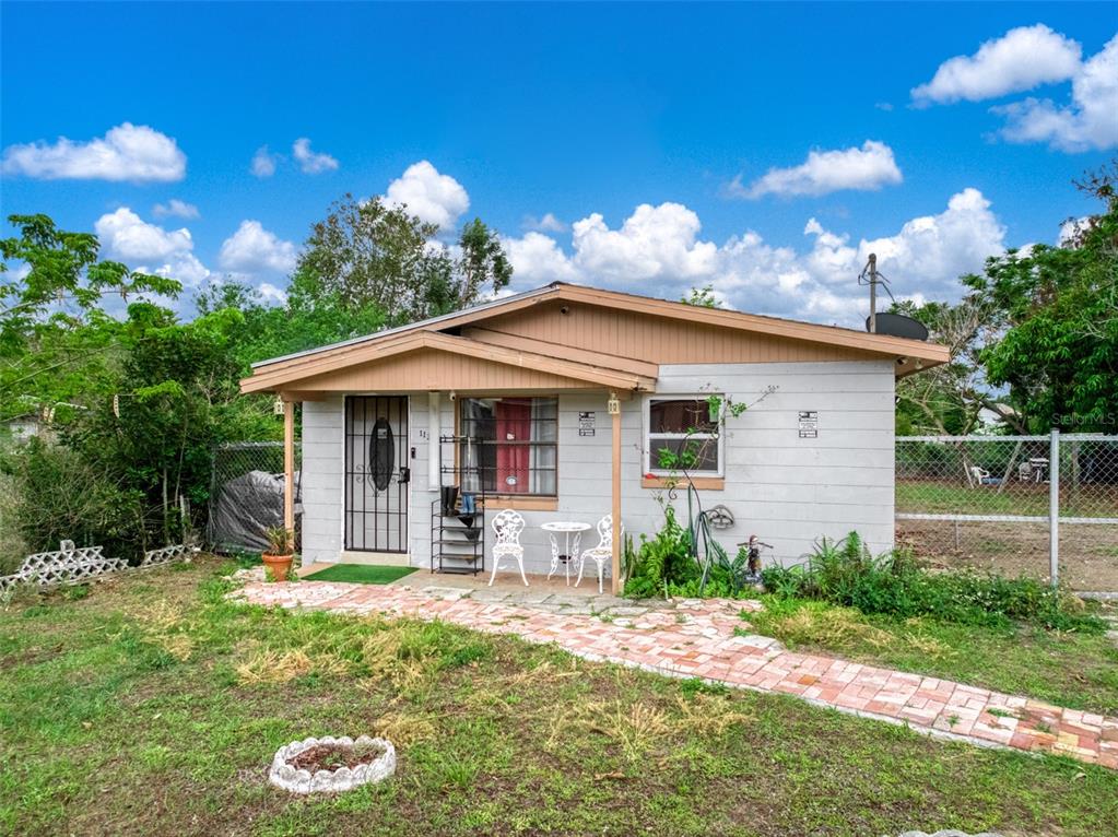 A small, single-story house with a brick walkway and a covered front porch — 113 ANDERSON STREET, LAKE PLACID, FL