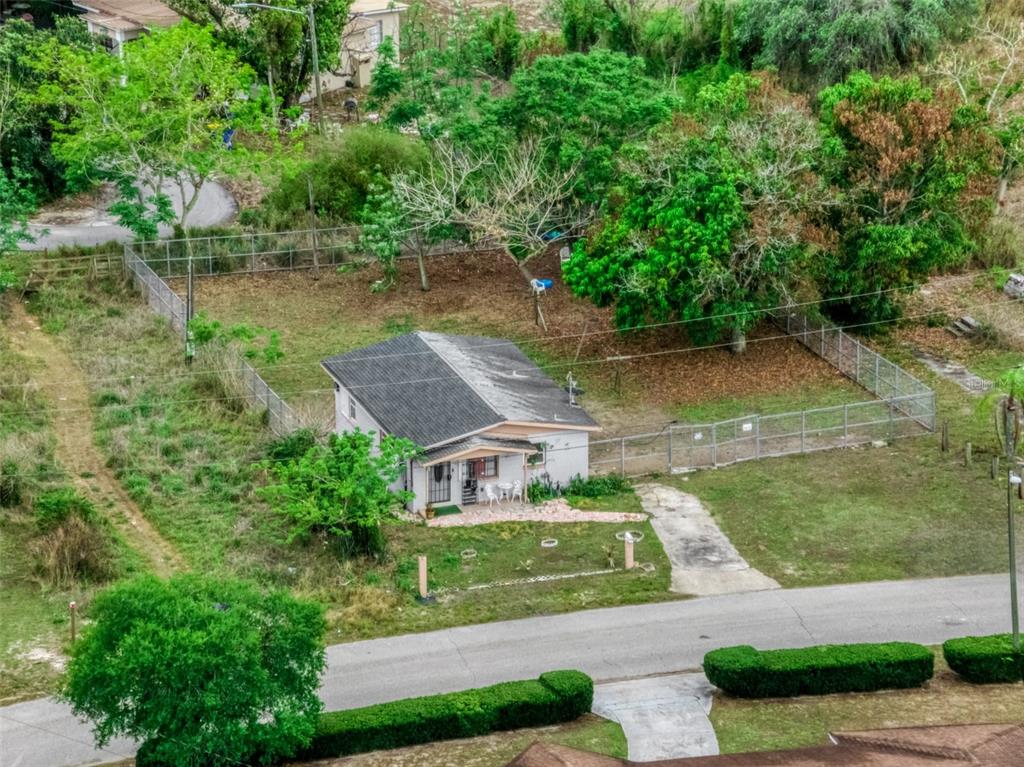 An aerial view shows a small, single-story house with a fenced yard and surrounding trees — 113 ANDERSON STREET, LAKE PLACID, FL