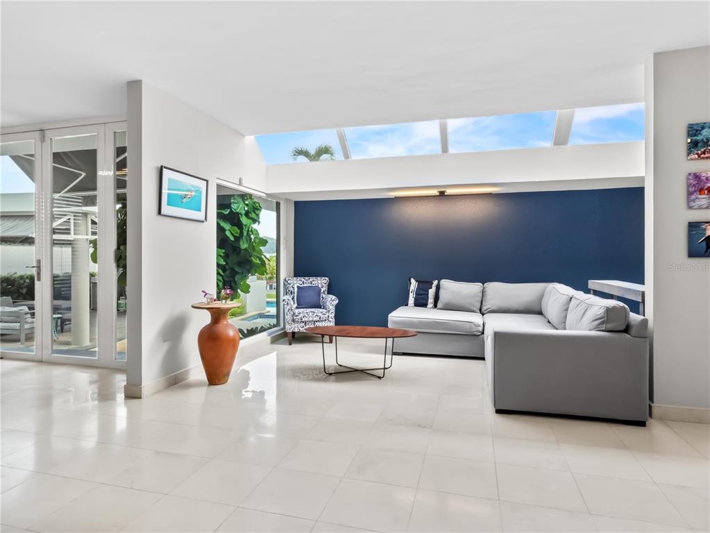 A living room features a grey sectional sofa, a blue accent wall, and a skylight — 236 REY FERNANDO, GUAYNABO, PR