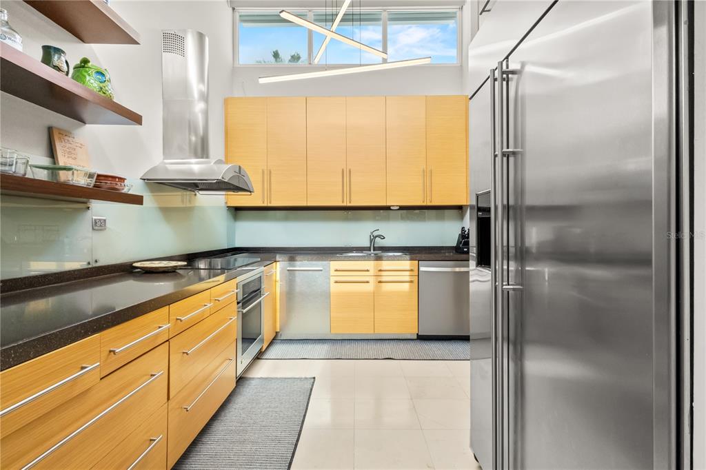 A modern kitchen features light wood cabinets, stainless steel appliances, and dark countertops — 236 REY FERNANDO, GUAYNABO, PR