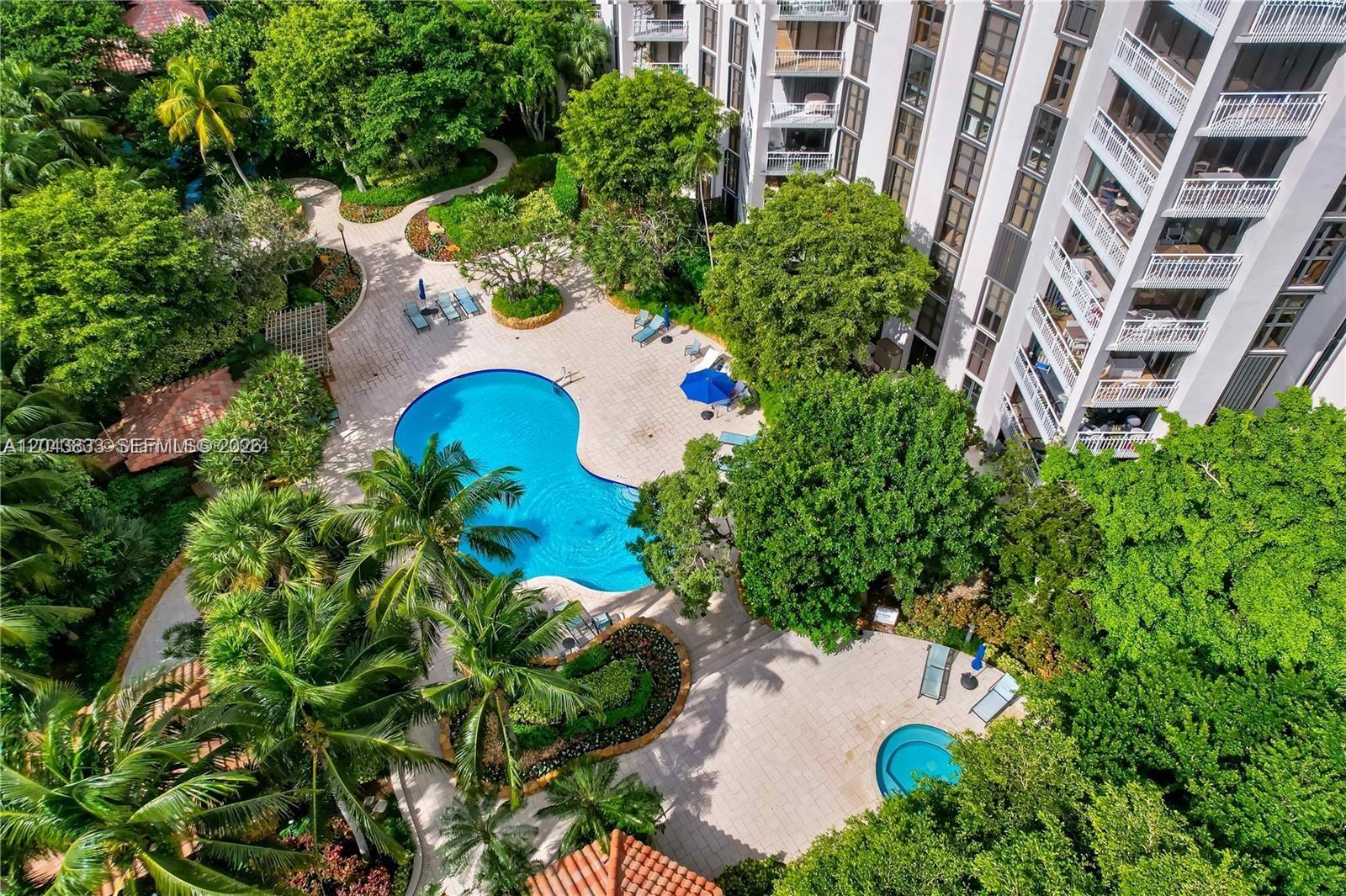 An aerial view shows a swimming pool and hot tub surrounded by landscaping and trees — 2000 Towerside Ter # 905, Miami FL 33138, MIAMI, FL