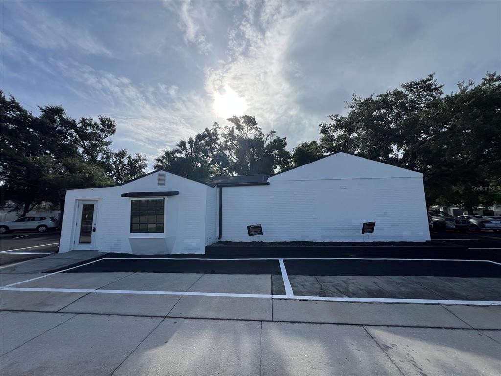 A white brick commercial building exterior features a glass door and a parking lot — 512 S DALE MABRY HIGHWAY, TAMPA, FL