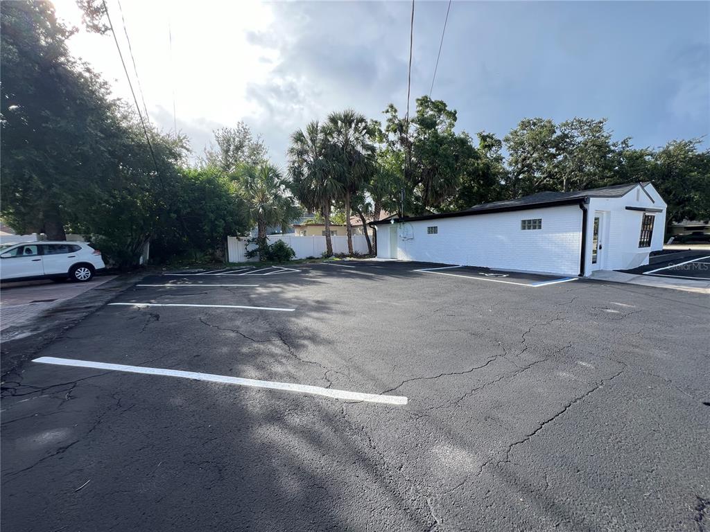 A white brick building sits next to a paved parking lot with marked spaces — 512 S DALE MABRY HIGHWAY, TAMPA, FL