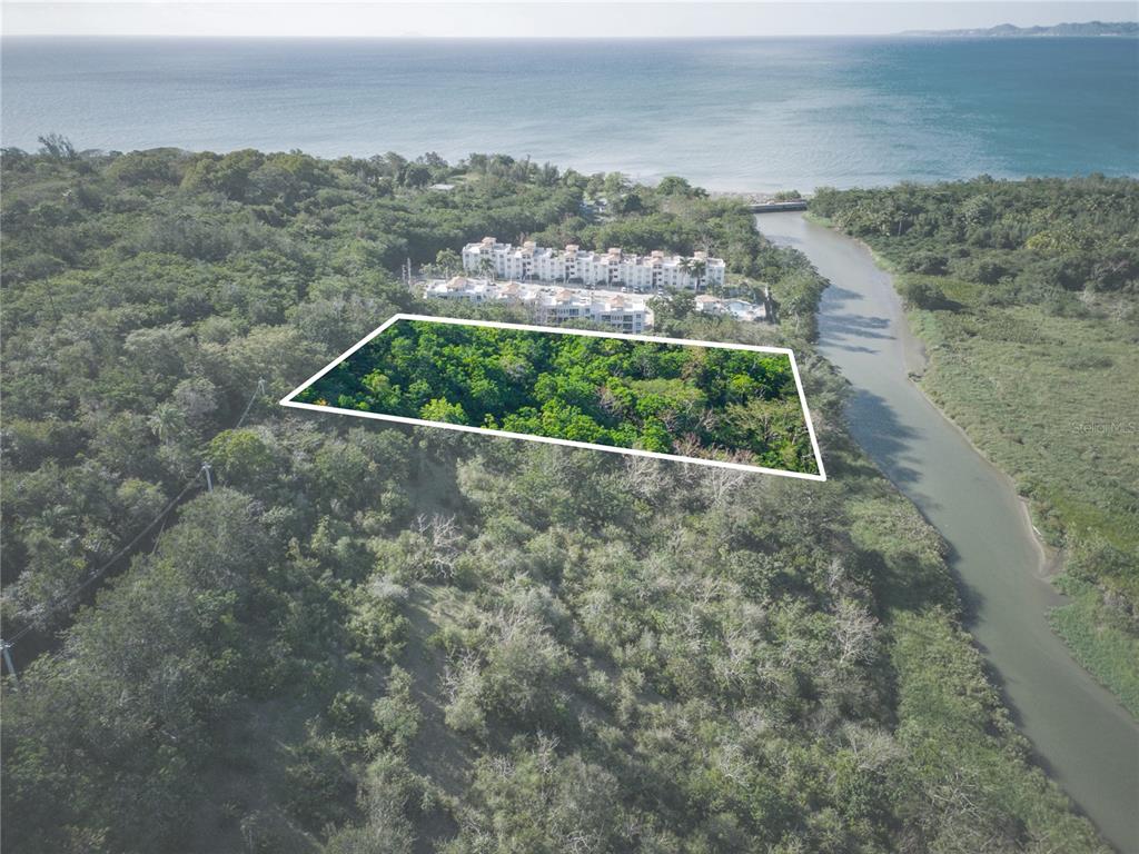 An aerial view shows a rectangular plot of land outlined in white near a river — 102 KM 8.2, GUANAJIBO WARD ROAD UNIT C-3, CABO ROJO, PR
