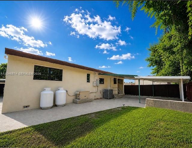 The exterior of a house features a concrete patio, two propane tanks, and a carport — 620 NW 182nd Ter, Miami Gardens FL 33169, MIAMI GARDENS, FL