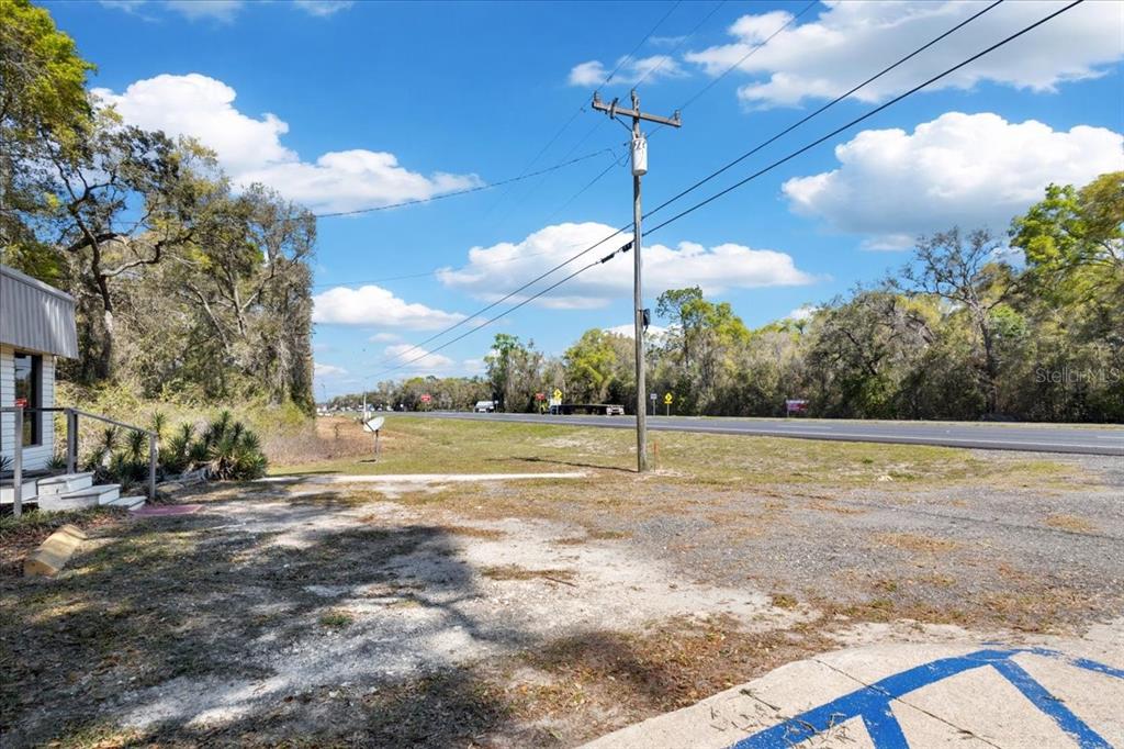 A gravel parking area sits in front of a utility pole and a paved road — 16648 NW US HIGHWAY 19, TRENTON, FL