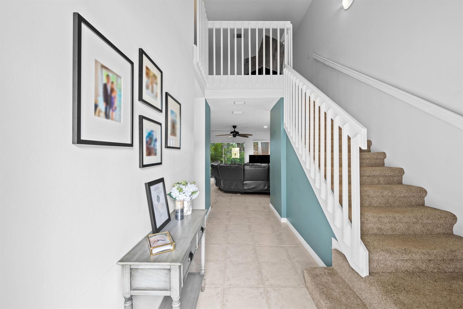 A foyer features a staircase with carpeted steps, a console table, and a hallway view — 6706 Boca Pines Trail # C, Boca Raton FL 33433, BOCA RATON, FL