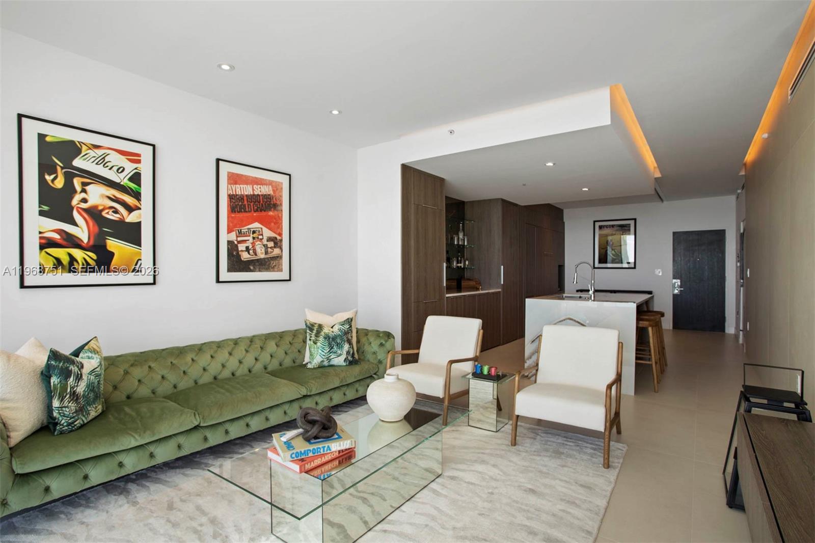 A living room features a green tufted sofa, two white armchairs, and an open kitchen — 900 Biscayne Blvd # 4307, Miami FL 33132, MIAMI, FL