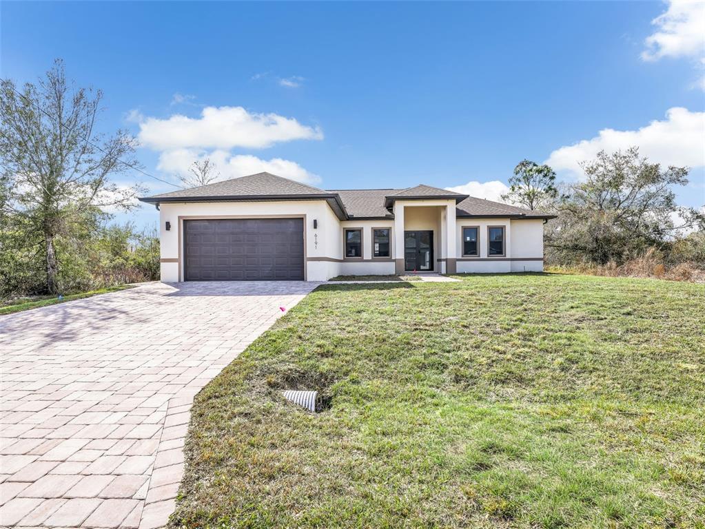 A single-story house with a paved driveway, two-car garage, and a light-colored stucco exterior — 6191 KAMBACH STREET, PORT CHARLOTTE, FL