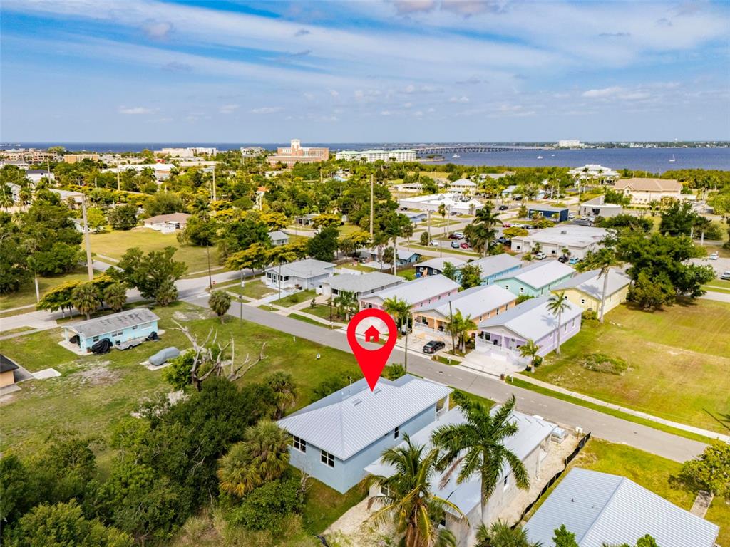 An aerial view shows a light blue house with a metal roof and palm trees — 627 FITZHUGH AVENUE, PUNTA GORDA, FL