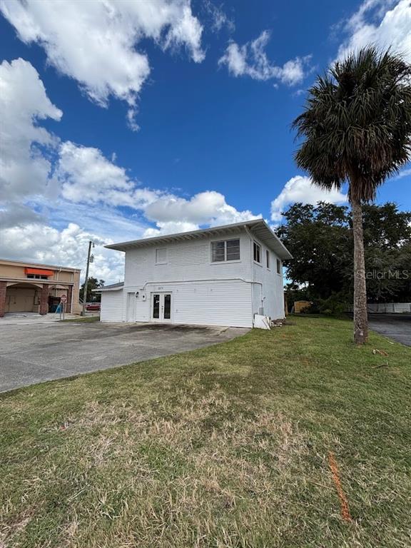 A two-story white building with horizontal siding stands next to a paved parking lot — 1871 S RIDGEWOOD AVENUE, SOUTH DAYTONA, FL