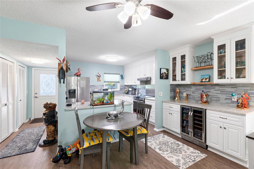 A kitchen and dining area with white cabinets, light blue walls, and a small round table — 2259 COSTA RICAN DRIVE UNIT 23, CLEARWATER, FL