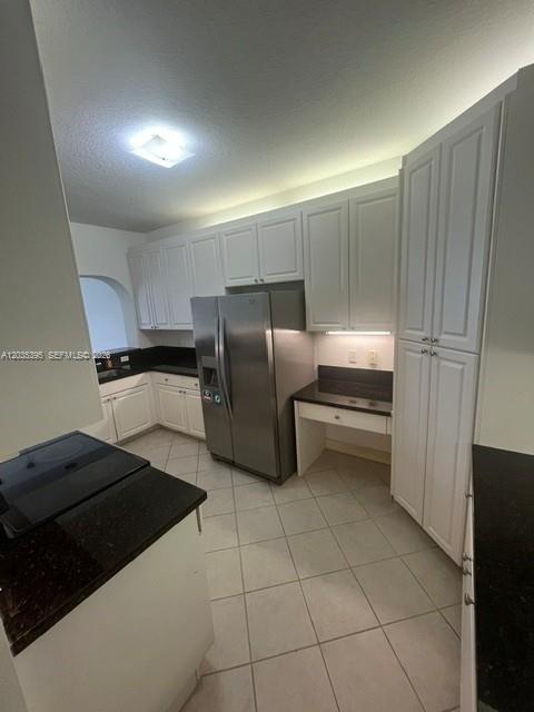 A kitchen with white cabinets, stainless steel appliances, and dark countertops on a tiled floor — 10720 NW 66th St # 305, Doral FL 33178, DORAL, FL