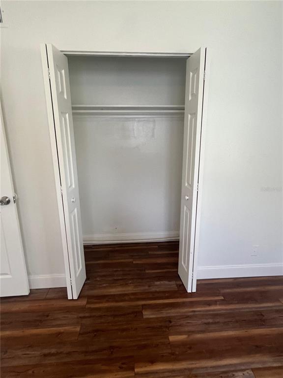 An open white bifold closet door reveals a shelf inside a room with wood-look flooring — 2227 NOTTINGHAM ROAD, SOUTH DAYTONA, FL