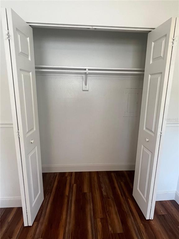 A closet with white bifold doors, a single shelf, and wood-look flooring — 2227 NOTTINGHAM ROAD, SOUTH DAYTONA, FL