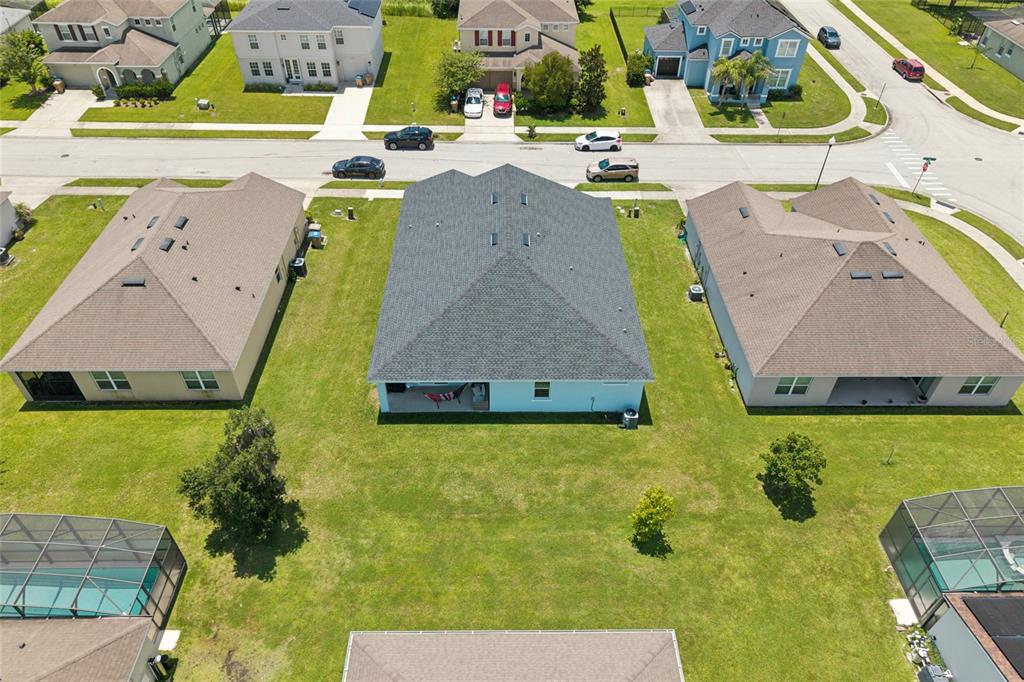 An aerial view shows a residential house with a gray roof and backyard lawn — 4902 PALL MALL STREET E, KISSIMMEE, FL
