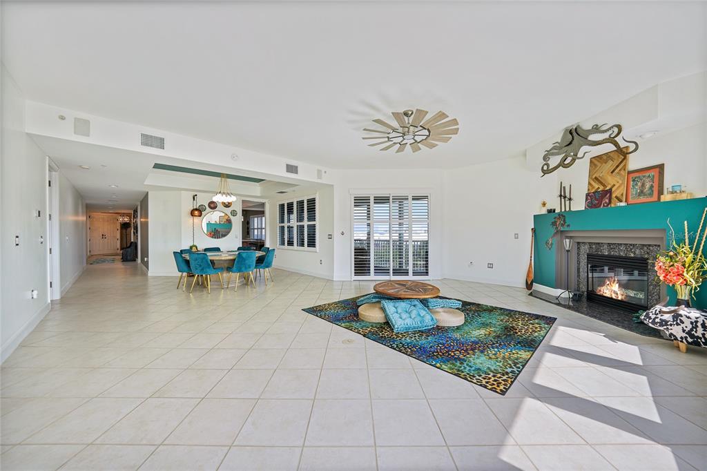 A spacious living and dining area features tile floors, a fireplace, and a ceiling fan — 2590 N BEACH ROAD UNIT 5, ENGLEWOOD, FL