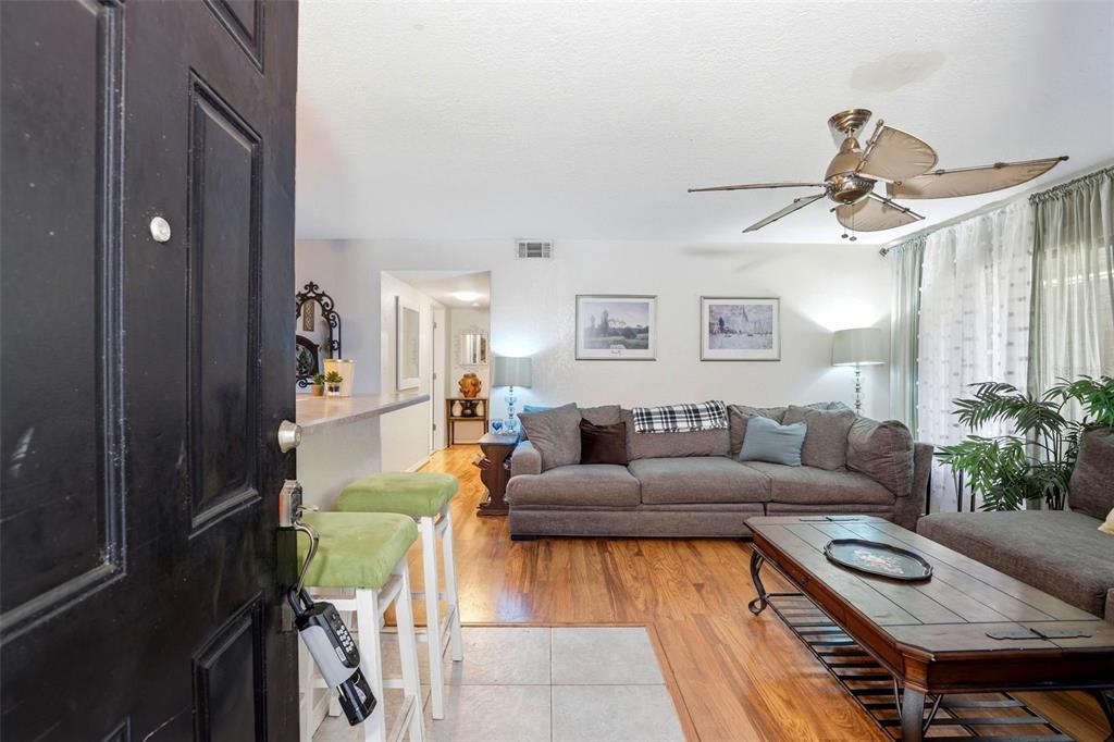 A living room with wood floors, a grey sectional sofa, and a ceiling fan — 2542 OAK PARK WAY UNIT 101, ORLANDO, FL