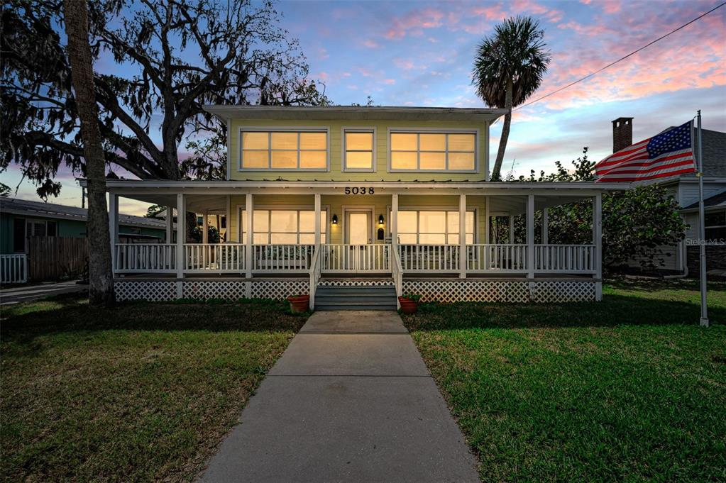 An aerial view shows a waterfront house with a dock, two boats, and trees — 5038 SUNSET BOULEVARD, PORT RICHEY, FL