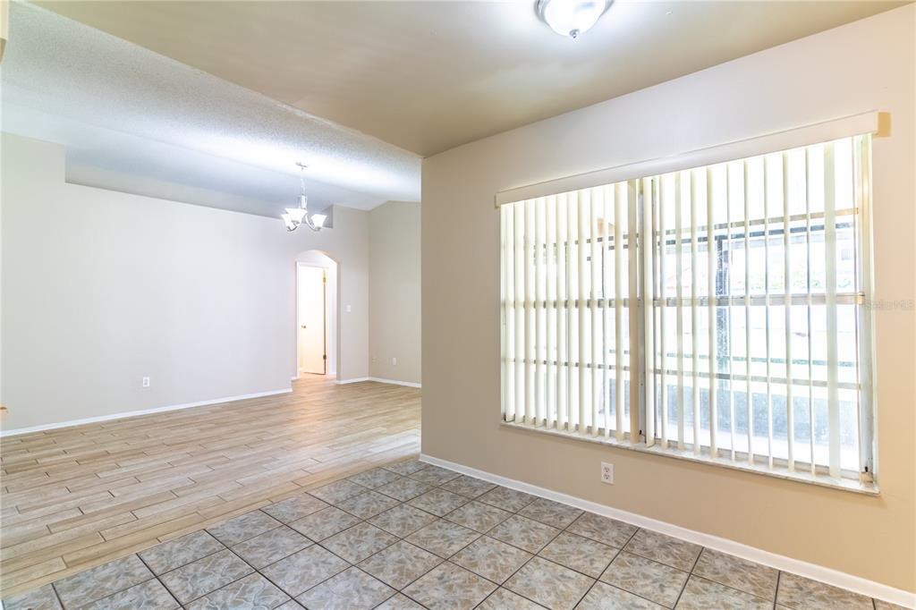 A room with tiled flooring and vertical blinds on a large window overlooks another area — 9624 TETLEY COURT, ORLANDO, FL