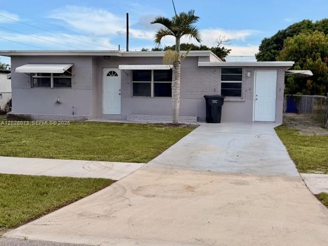 A single-story gray house with a palm tree, two white doors, and a concrete driveway — 5608 Garfield St, Hollywood FL 33021, HOLLYWOOD, FL