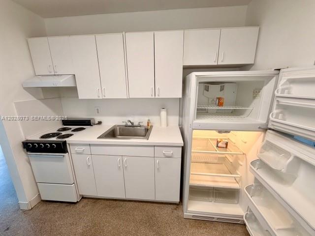 A small kitchen features white cabinets, a stove, a sink, and an open refrigerator — 5608 Garfield St, Hollywood FL 33021, HOLLYWOOD, FL